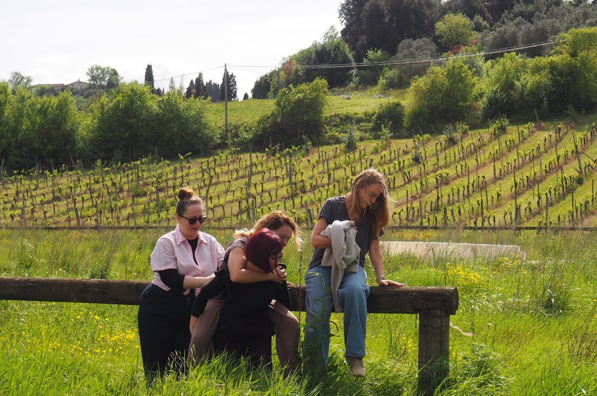 Team members chatting on a bench overlooking a vineyard